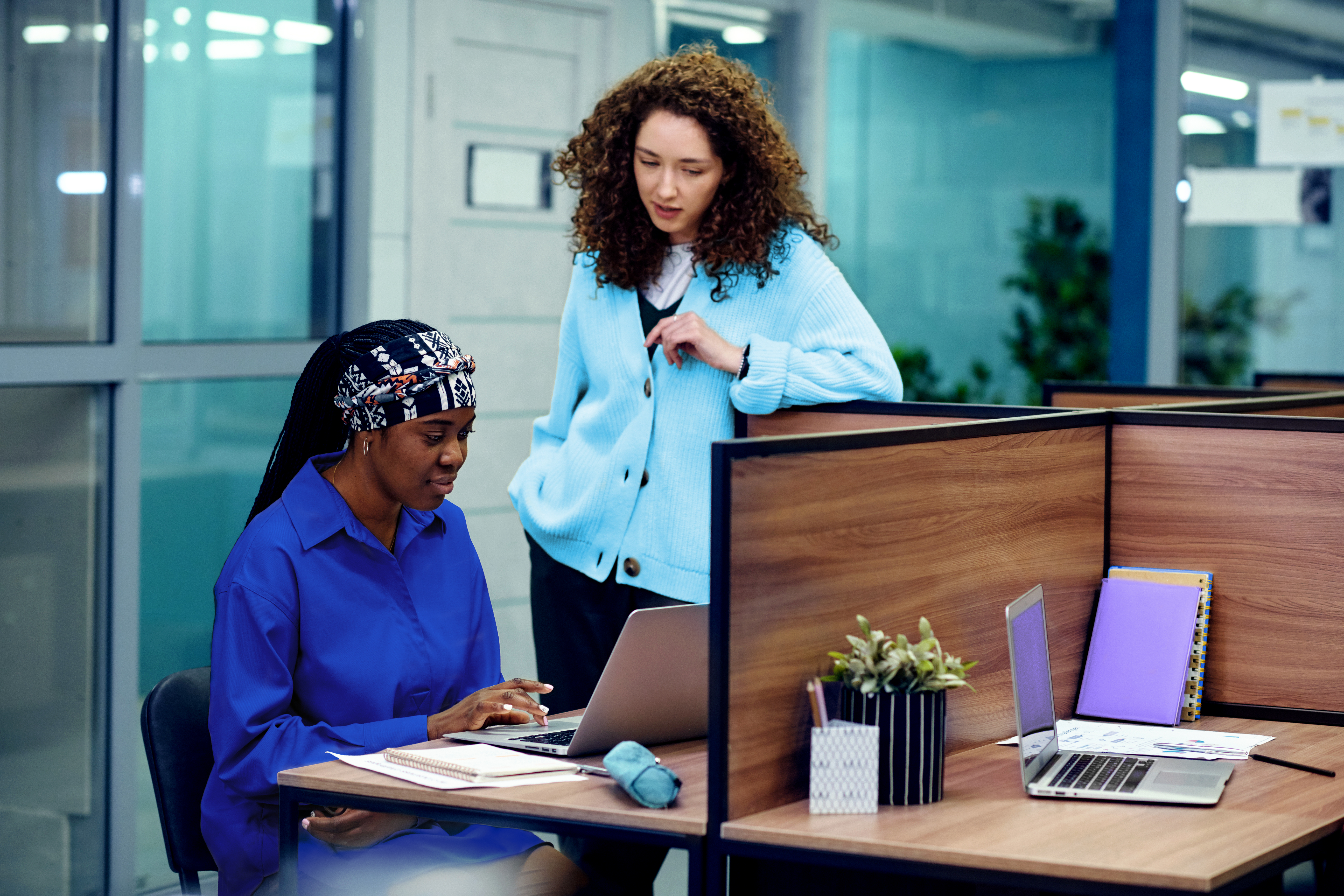 Two professionals engaged in focused discussion at their workspace, showcasing seamless collaboration supported by AI-driven financial close technology.